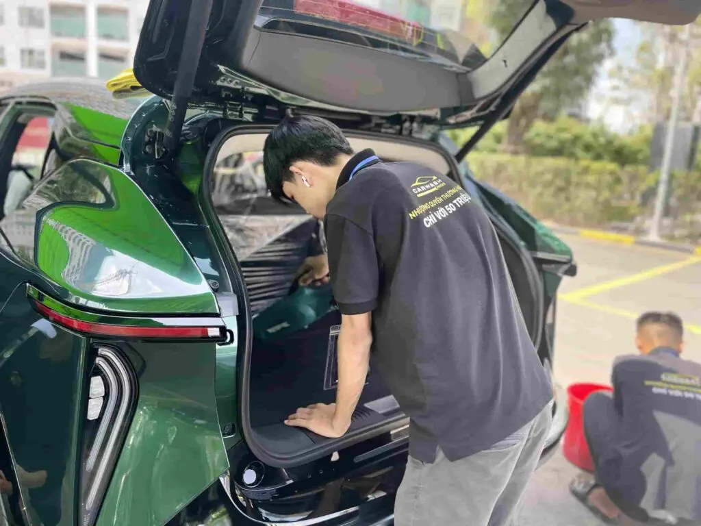 Kỹ thuật viên đang kiểm tra mức độ bẩn ở cốp xe.